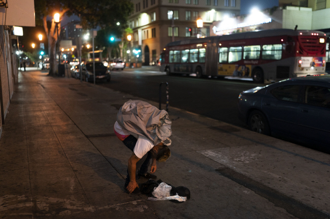 지난해 8월 23일 미 캘리포니아주 로스앤젤레스(LA)에서 한 30대 남성이 마약성 진통제 펜타닐을 투약한 후 길을 걷다 잠이 들어 허리를 숙이고 있다.AP