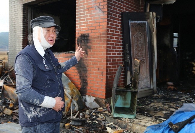 지난 9일 오전 경북 경주시 내남면 한 주택 화재 당시 집 안에 있던 노부부를 구조한 손수호 씨가 불에 탄 집을 가리키고 있다.  경주시청 제공