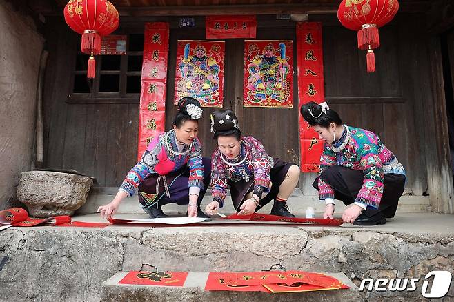 계묘년 춘절을 사흘 앞둔 19일 중국 구이저우성 단자이현에서 소수민족인 먀오족 여성들이 복을 기원하는 장식품을 준비하고 있다. 2023.1.19. ⓒ AFP=뉴스1 ⓒ