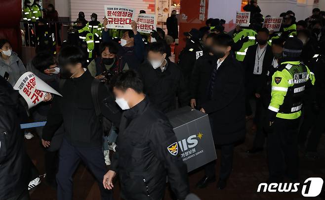 국가정보원 관계자들이 지난 18일 서울 중구 전국민주노동조합총연맹(민주노총) 서울 사무실에서 국가보안법 위반 혐의로 압수수색을 마친 후 압수품 상자를 들고 나가고 있다. 2023.1.18/뉴스1 ⓒ News1 이동해 기자
