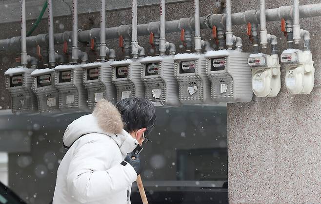연초부터 급등한 난방비가 시민들의 경제적 부담을 가중시키는 가운데 26일 서울 시내 눈 쌓인 가스계량기 앞을 한 시민이 지나가고 있다. 연합뉴스