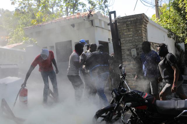 아이티 정부의 무능을 성토하는 경찰들이 26일(현지시간) 수도 포르토프랭스의 아리엘 앙리 총리 관저를 공격하고 있다. 포르토프랭스=로이터 연합뉴스