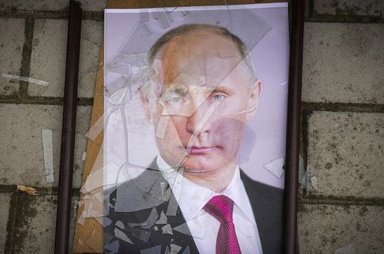 지난달 16일(현지시간) 우크라이나 남부 헤르손의 한 교도소 인근에 블라디미르 푸틴 러시아 대통령의 사진이 바닥에 내동댕이쳐져 있다. AP=연합뉴스