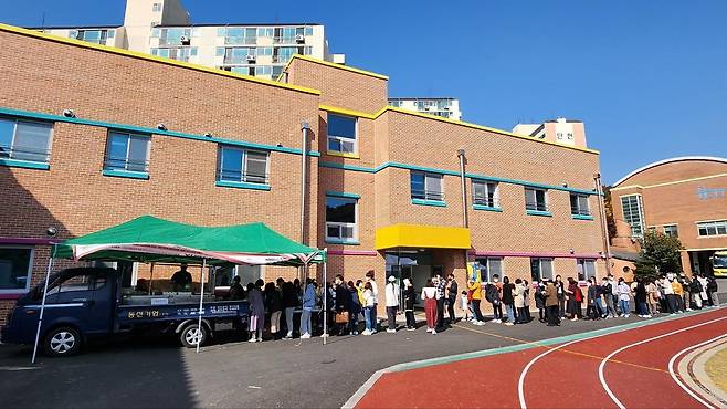(고양=연합뉴스) 권숙희 기자 = 지난해 10월 경기 고양시 장애아 대상 특수교육기관인 '홀트학교'에서 열린 한 대관 행사에서 백동민(51) 대표의 떡볶이 푸드트럭 앞으로 사람들이 길게 줄을 선 모습. 이날 행사 수익금은 전액 홀트학교에 기부했다. 2023.1.29.