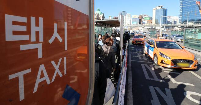 30일 오후 서울 중구 서울역 택시 승강장에서 택시를 이용하는 시민들의 모습. /뉴스1