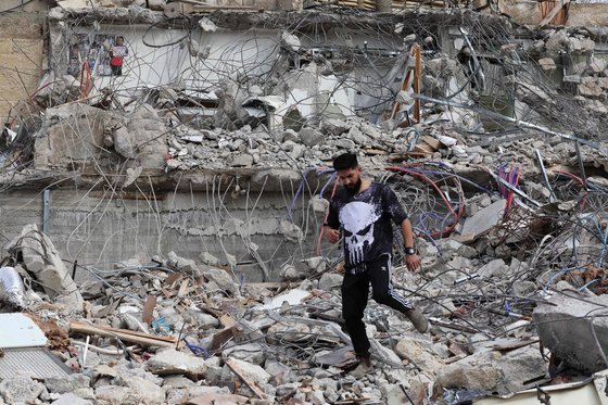 이스라엘 정부가 팔레스타인인 총격범에 대한 이스라엘 거주권 박탈을 결정했다. 팔레스타인 남성이 29일(현지시간) 동예루살렘에서 이스라엘군의 불도저에 밀려 폐허가 된 집 잔해 위를 걸어가고 있다. AFP=연합뉴스