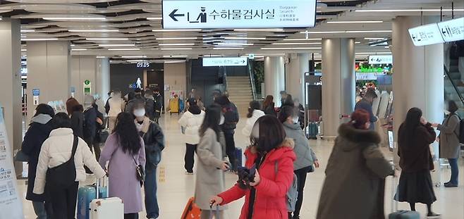 실내 마스크 착용이 ‘의무’에서 ‘권고’로 변경된 30일 오전, 김포국제공항 국내선 여객터미널을 찾은 이용객들이 마스크를 쓴 채  체크인 준비를 하고 있다. <지홍구 기자>