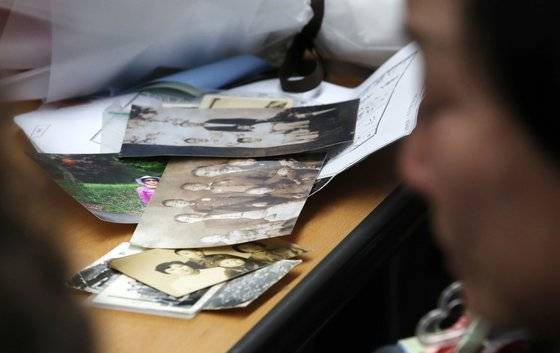 헤어진 뒤 서로 찾지 못하던 장기 실종 가족 장택훈, 장희재, 장경인, 장희란 남매가 31일 오후 서울 동작경찰서에서 58년 만에 다시 만나 가족사진을 보며 이야기 나누고 있다. 테이블에 서로가 가져온 옛 사진들이 놓여 있다. 뉴스1