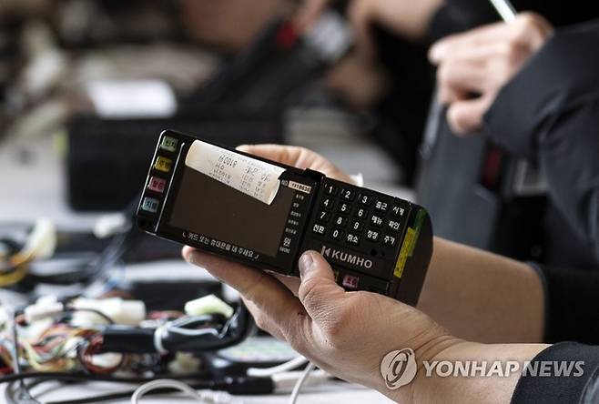 앱 미터기가 도입되기 전인 2019년 2월 18일 미터기 교체 작업 장소인 서울 마포구 난지천 공원 주차장에서 관계자들이 기계식 미터기 정보를 업데이트 하고 있다. 현재 도입된 앱 미터기는 일괄적으로 업데이트가 가능해 수작업이 필요 없다. [자료=연합뉴스]