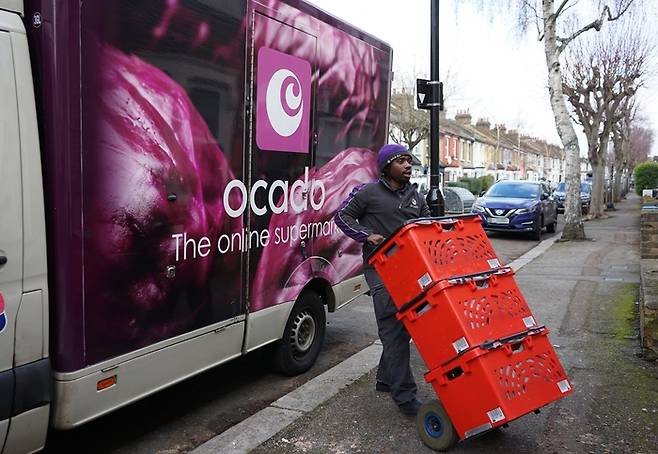 영국 북런던 지역의 고객에게 상품을 배송하는 오카도 배송차량 직원이 상품을 운반하고 있다. <사진=롯데쇼핑>