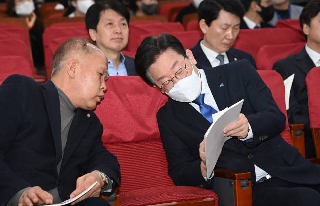 무슨 얘기… ‘대장동·위례 개발 특혜 의혹’ 2차 검찰 소환 조사를 앞둔 이재명(오른쪽) 더불어민주당 대표가 31일 오전 국회 의원회관에서 열린 부실 미분양 주택 매입임대 전환 토론회에 참석해 이용우 민주당 의원과 이야기를 나누고 있다. 김동훈 기자