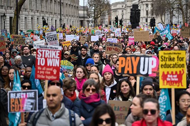 1일(현지 시각) 영국 런던 중심가에서 파업에 참여한 교사들이 플래카드와 깃발을 들고 구호를 외치고 있다. 이날 영국에선 10여 년 만의 최대 규모 파업이 발생했다./AFP 연합뉴스