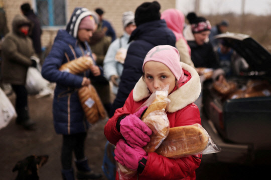지난달 31일(현지시간) 우크라이나 남부 헤르손 인근에서 한 소녀가 자원봉사자에게 배급받은 구호식량을 들고 있습니다. 러시아군의 폭격으로 기간시설이 파괴되면서 에너지, 식량 공급이 제대로 이뤄지지 않아 민간인들이 큰 고통을 겪고 있습니다.                                                                  로이터 연합뉴스