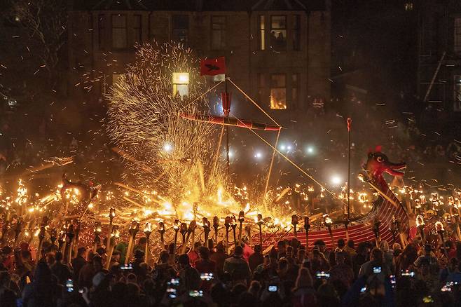 유럽 최대 규모의 불 축제 ‘업 헬리 아’가 31일(현지시각) 영국 스코틀랜드 북동부의 셰틀랜드 러윅에서 열렸다. 참가자들이 갤리선에 불을 붙이고 있다. 러윅/AP 연합뉴스