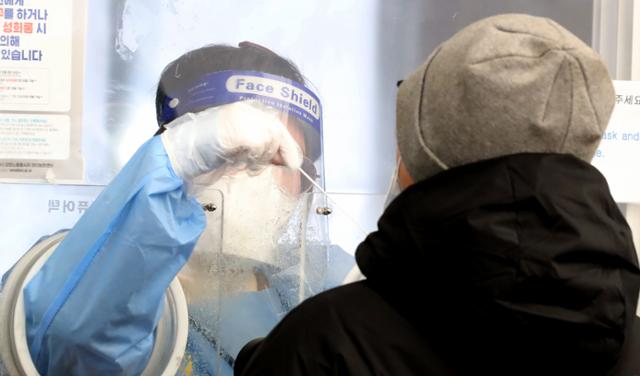 지난달 30일 서울 중구 서울역 코로나19 선별진료소에서 마스크를 착용한 의료진이 PCR검사를 위한 검체를 채취하고 있다. 뉴스1