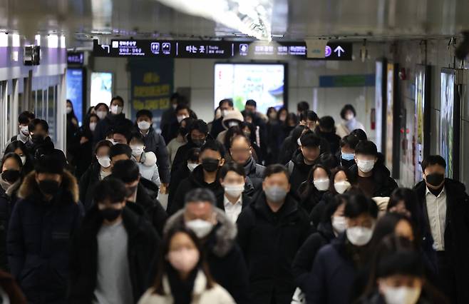 Masked citizens walk in the passageway of Gwanghwamun Station on the Seoul Subway Line No.5, Tuesday. (Yonhap)