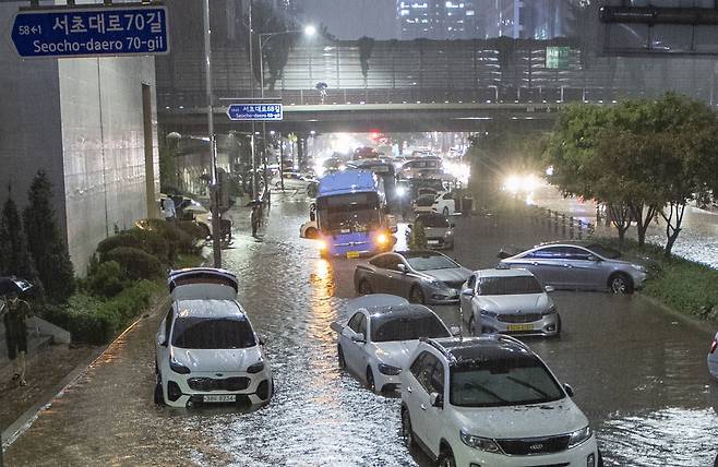 2022년 8월 8일 밤 서울과 경기북부 등 수도권에 기록적인 폭우가 내린 가운데 서울 강남역 일대 도로가 침수되어 시민들이 대피한 후 차들이 도로에 그대로 놓여있다. /조선DB