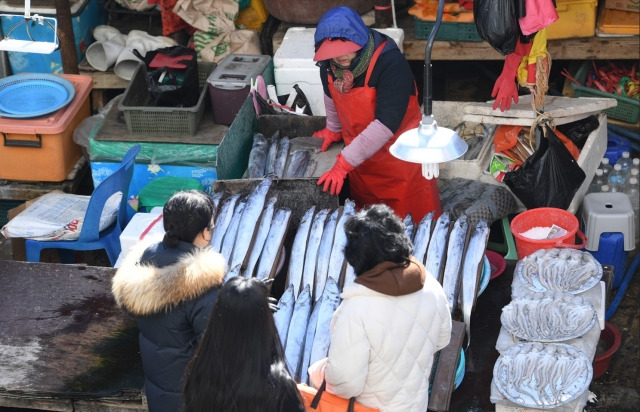 지난달 30일, 부산 자갈치시장 한 가판에서 상인이 손님들에게 생선을 팔고 있다. 부산=이한형 기자