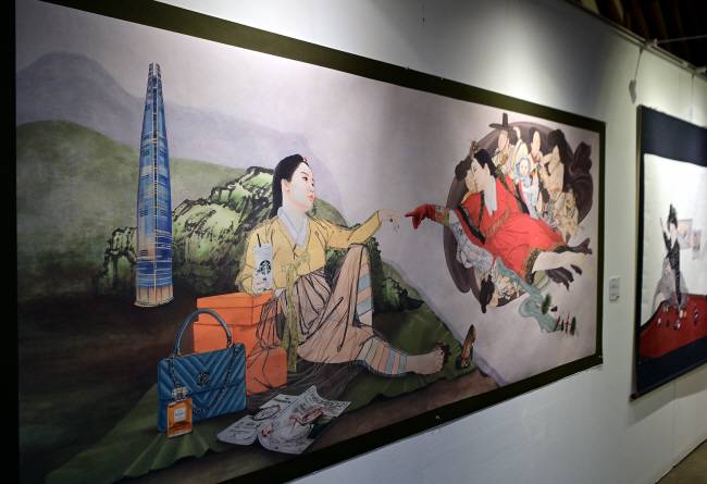 삼례문화예술촌 전시장에 걸린 김현정 작가의 작품. 미켈란젤로의 ‘천지창조’를 패러디해 미혼 여성과 기혼 여성이 손끝을 맞대고 있는 그림을 그려놓고 ‘천지 차이’란 제목을 달았다.