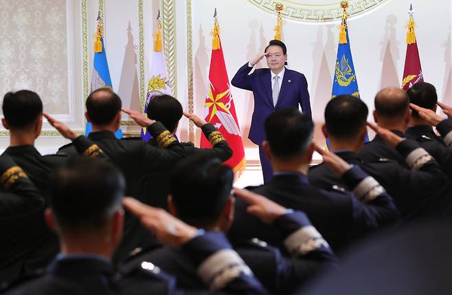 윤석열 대통령이 3일 청와대 영빈관에서 열린 상반기 육군·해군·해병대·공군 준장 진급자 및 진급 예정자 삼정검 수여식에서 진급 장성으로부터 거수경례를 받고 있다. 삼정검의 '삼정'은 육·해·공군이 일치하여 호국·통일·번영의 3가지 정신 달성을 의미한다. [연합]