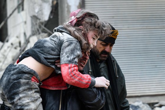 튀르키예·시리아에서 발생한 지진으로 건물에 깔렸떤 한 여성이 구조돼 이송되는 모습. AFP=연합뉴스