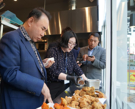윤홍근 제너시스BBQ 회장(왼쪽)이 신제품 ‘핫 황금올리브치킨’ 시리즈를 살펴보고 있다. (사진=제너시스BBQ)