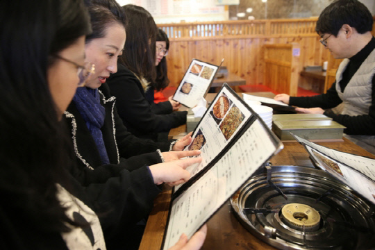 목원대에 재학중인 중국인 유학생 등이 지난 6일 대전 서구 도안동에 있는 한 음식점을 찾아 중국어 등 외국어로 설명이 돼 있는 메뉴판을 살펴보고 있다. 사진=목원대 제공