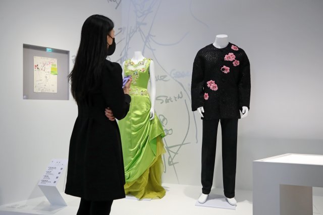 배우 장동건이 패션쇼에서 착용했던 앙드레 김의 의상(오른쪽)을 관람객이 보고 있다. 뉴시스