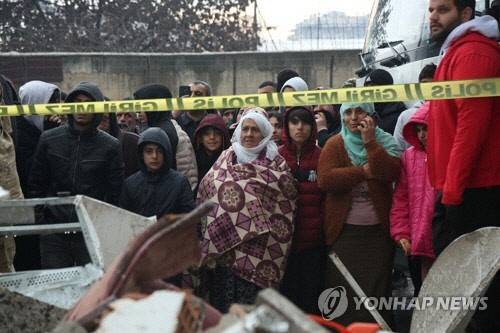 6일(현지시간) 규모 7.8 강진으로 무너진 튀르키예 남동부 디야르바크르의 건물 앞에서 주민들이 구조 작업을 지켜보고 있다. 디야르바크르[튀르키예] 로이터=연합뉴스