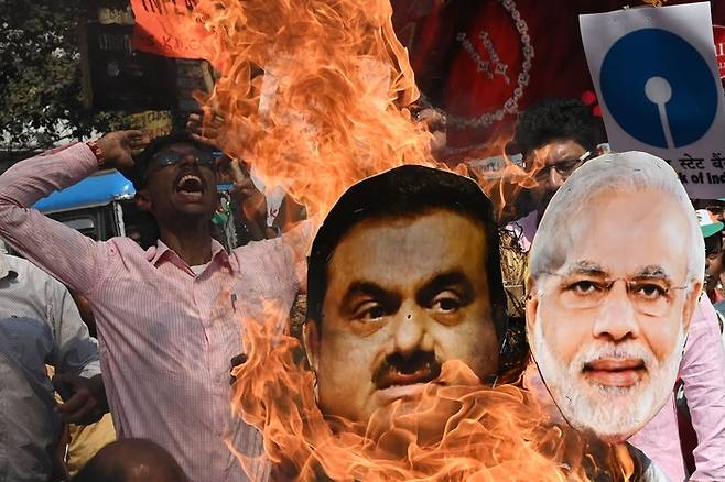 인도 제1야당 인도국민회의당의 활동가가 6일(현지시간) 콜카타에서 열린 집회에서 나렌드라 모디 총리와 가우탐 아다니 회장의 사진을 불태우고 있다. AFP연합뉴스