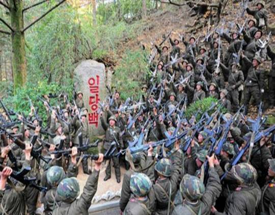 오는 8일 북한의 인민군 창건일(건군절) 75주년을 앞두고 있는 가운데 북한 대외선전매체 ‘우리민족끼리’는 6일 김일성 주석이 ‘일당백’ 구호를 제시한지 60주년이 됐다고 선전했다. 사진은 북한 인민군이 일당백 문구를 둘러싸고 함성을 지르는 모습. 연합뉴스·우리민족끼리 홈페이지 캡처.