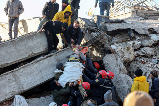 강진 발생 다음날인 7일(현지시간) 튀르키예 남부 카흐라만마라슈의 건물 잔해에서 구조대가 생존자를 끌어내고 있다. (사진=AFP)