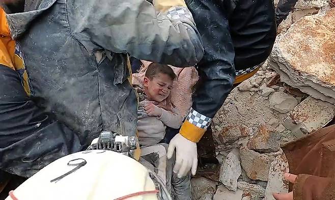 시리아 북서부의 이들리브에서 민간 구조대원들이 건물 잔해에 갇힌 한 아이를 구조하고 있다. 국제 사회의 구조 장비가 들어가지 못해, 잔해를 치울 중장비가 턱없이 부족하다. /UPI 연합뉴스
