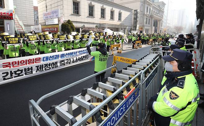 8일 오전 서울 영등포구 여의도동 국민의힘 당사 앞에서 열린 간호법 제정 촉구 집회 참가자들이 국민의힘 당사를 향해 손팻말을 든 채 구호를 외치고 있다. 신소영 기자