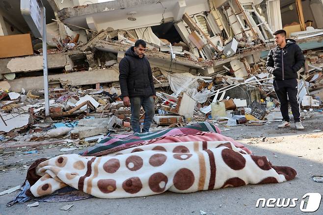 8일(현지시간) 튀르키예 하타이에서 대지진 이틀 만에 건물 잔해에 깔린 한 남성이 극적 구조됐지만 그의 아내와 두 딸은 끝내 목숨을 잃고 담요에 덮인 채 차가운 땅바닥에 누워있다. 2023.2.8 ⓒ 로이터=뉴스1 ⓒ News1 정윤미 기자