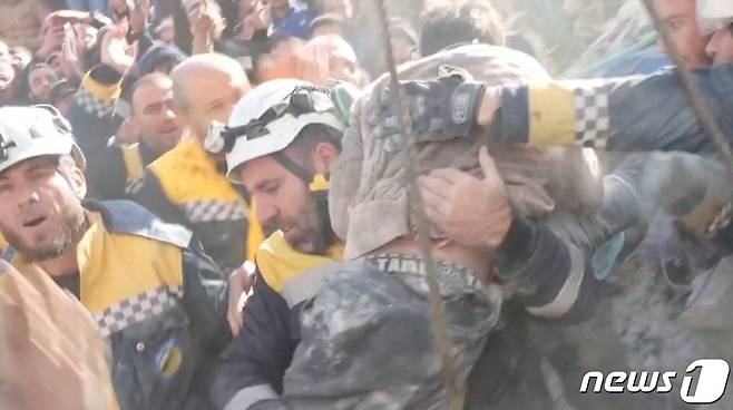 8일(현지시간) 시리아 잔다리스에서 자원봉사자들이 지진 잔해 속에서 구조한 소년을 안고 안전한 곳으로 옮기고 있다. 골든타임 72시간이 지난 후에도 기적같은 구조가 이어지고 있다. ⓒ 로이터=뉴스1 ⓒ News1 권진영 기자