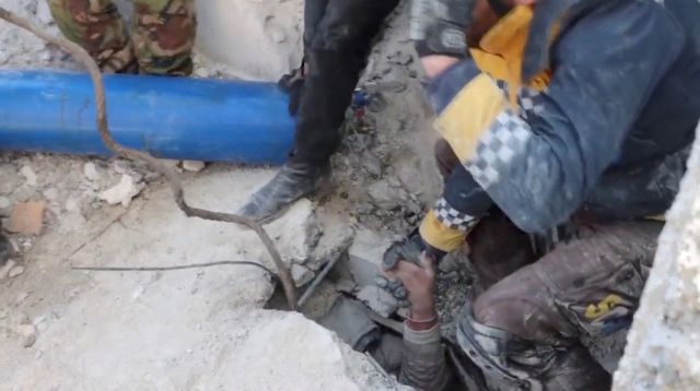 지진으로 무너진 시리아 북서부 알레포주 잔다리스의 건물 잔해에 파묻힌 한 소년이 8일(현지시간) 팔을 뻗어 구조대원 손을 잡고 있다. 로이터연합뉴스