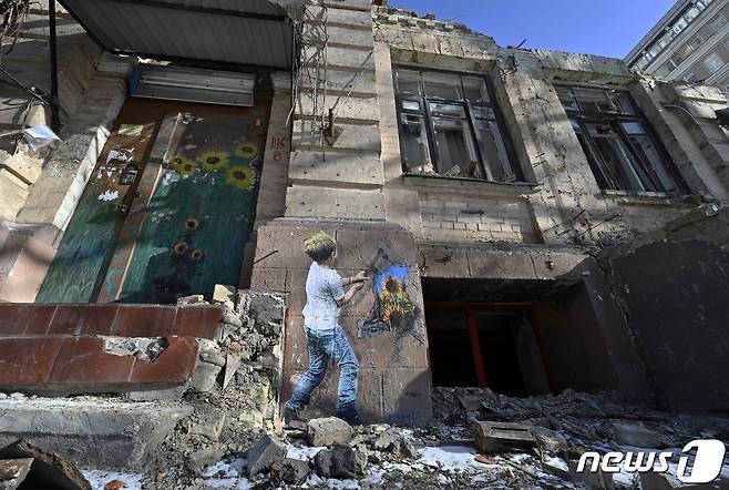 8일(현지시간) 우크라이나 키이우에서 러시아 군의 포격을 받아 파괴된 아파트 벽에 거리 예술가 티브이보이가 그린 벽화가 보인다. ⓒ AFP=뉴스1 ⓒ News1 우동명 기자