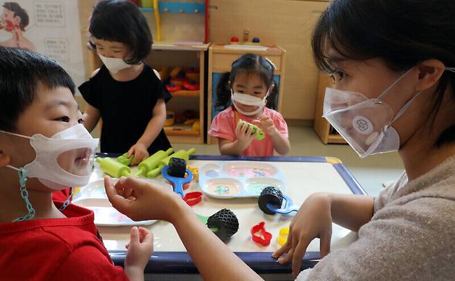 지난해 종로구청 어린이집에서 교사와 어린이들이 투명마스크를 쓰고 있다. 연합뉴스
