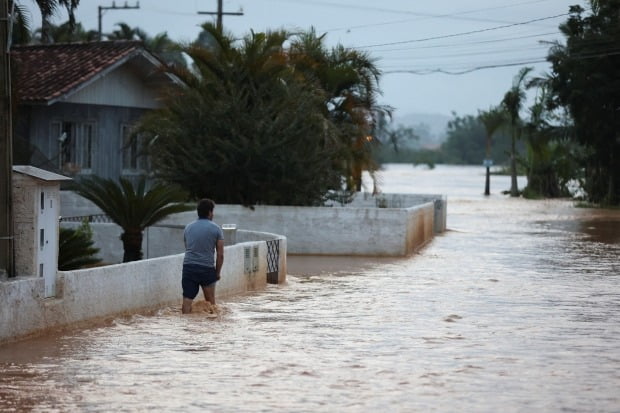 폭우로 물에 잠긴 거리를 걷는 브라질 주민. 사진은 지난해 12월 브라질 남부 사타카타리나주 카넬린 폭우 현장. 특정 기사와 무관함. / 사진=로이터