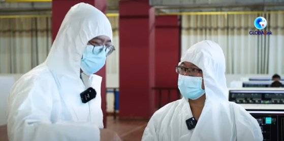 방호복을 입은 직원들이 돼지 사육 빌딩에서 근무하고 있다. 사진 유튜브 캡처