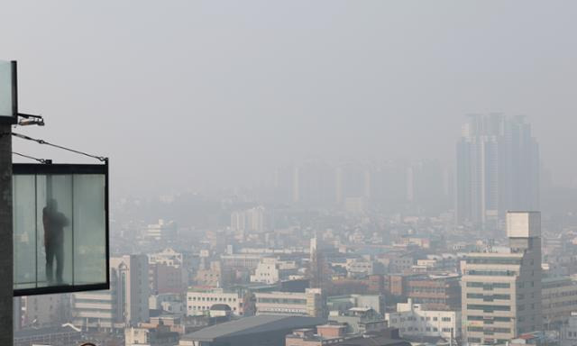 초미세먼지 주의보가 내려진 지난 8일 충북 청주시의 한 카페에서 한 시민이 뿌연 하늘을 바라보고 있다. 연합뉴스