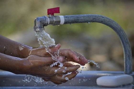 지난해 10월 유니세프 직원들이 콜레라 발생을 막기 위해 시리아 난민 캠프촌에 물을 가져다 난민들의 손을 씻게 하고 있다. AP=연합뉴스