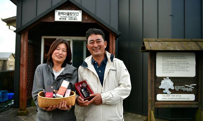 동백고장보전연구회의 오동정 대표(오른쪽)와 최혜연 사무국장이 제주 서귀포시 신흥2리 동백마을 방앗간 앞에서 동백기름 제품을 들고 포즈를 취하고 있다. 오 대표 등은 동백나무 심기가 후대에게 물려줄 제주 환경을 살리는 중요한 프로젝트라고 강조한다.