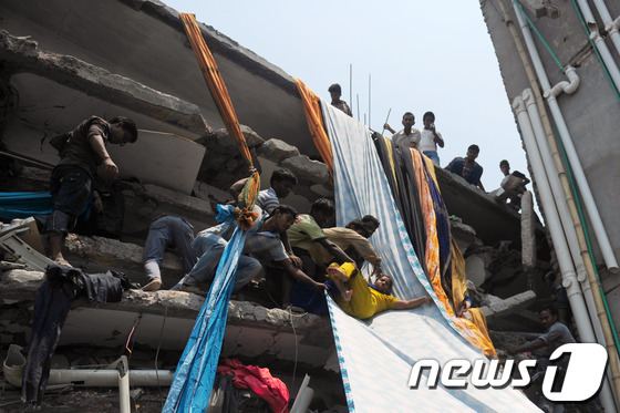 2013년 방글라데시 의류공장 건물 붕괴 현장에서 생존자들을 구조하는 모습. ⓒ AFP=News1