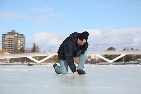 지난 8일 캐나다 오타와의 리도 운하 스케이트장에서 국립수도권위원회 직원이 얼음 상태를 점검하고 있다. APF 연합뉴스