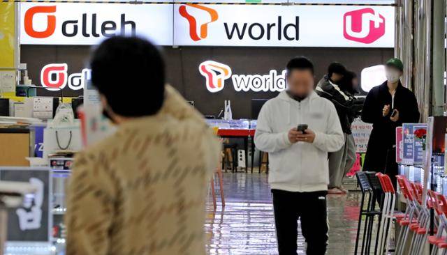 16일 오후 서울 구로구 신도림테크노마트 휴대폰 매장 앞으로 시민들이 지나가고 있다. 윤석열 대통령은 15일 통신비 부담을 줄이기 위한 대책을 논의했다. 정부는 이동통신사와 5G 중간요금제의 기본 데이터 제공 확대, 시니어 요금제 출시 등 이용자의 요금 선택권을 확대하기 위한 협의를 한다고 밝혔다. 뉴스1