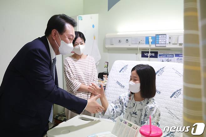윤석열 대통령이 22일 서울 종로구 서울대 어린이병원 소아외과 병실을 방문해 환아와 인사하고 있다. (대통령실 제공) 2023.2.22/뉴스1 ⓒ News1 오대일 기자