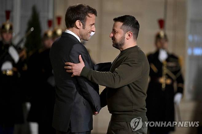 젤렌스키 우크라 대통령 맞는 마크롱 佛 대통령 (파리 AFP=연합뉴스) 에마뉘엘 마크롱 프랑스 대통령(왼쪽)이 8일(현지시간) 마크롱 대통령, 올라프 숄츠 독일 총리와 회담하러 파리 엘리제궁을 찾은 볼로디미르 젤렌스키 우크라이나 대통령을 맞고 있다. 젤렌스키 대통령은 작년 2월 러시아의 우크라이나 침공 이후 처음으로 이날 영국을 찾은 데 이어 프랑스를 방문해 전투기 등 무기를 더 많이 우크라이나에 지원해줄 것을 촉구했다. 2023.02.09 ddy04002@yna.co.kr