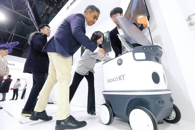27일(현지시간) MWC KT 전시관 내에서 관람객이 배송로봇을 체험하고 있다. [KT 제공]